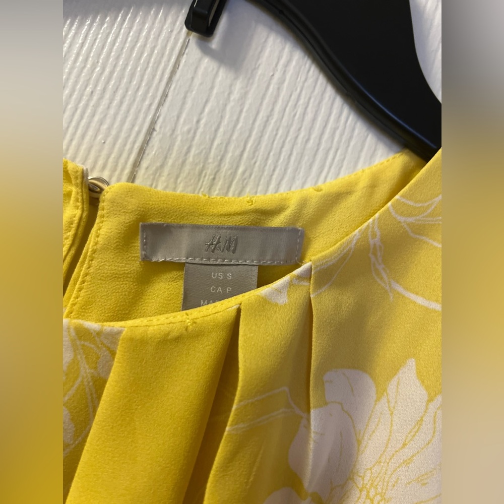 A stunning sleeveless mini dress in a vibrant and sunny yellow color.